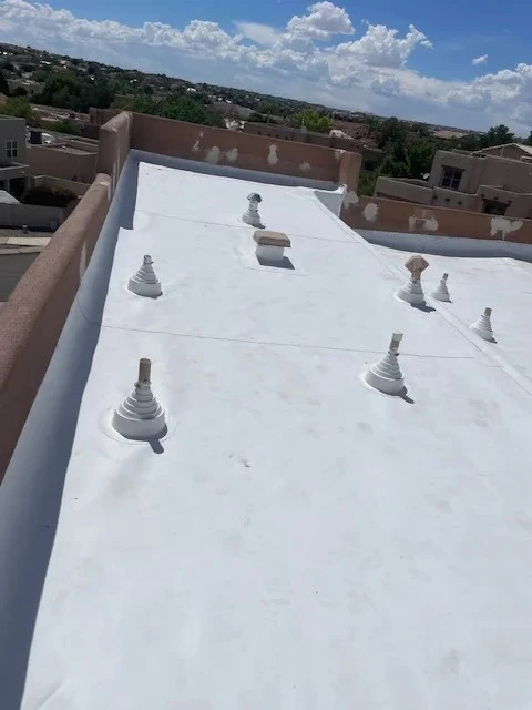A roof covered with white plastic sheeting, providing protection and insulation from the elements.